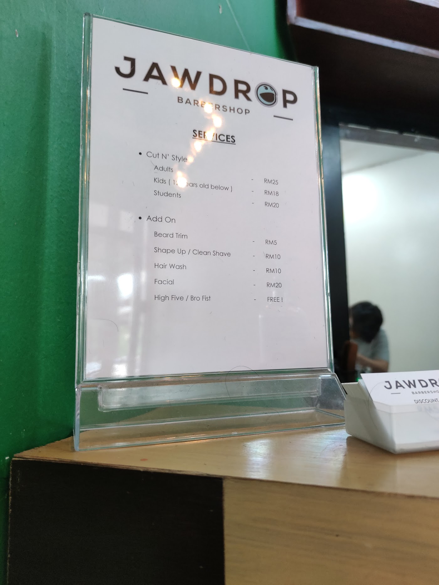 Jawdrop Barbershop services menu card on the counter