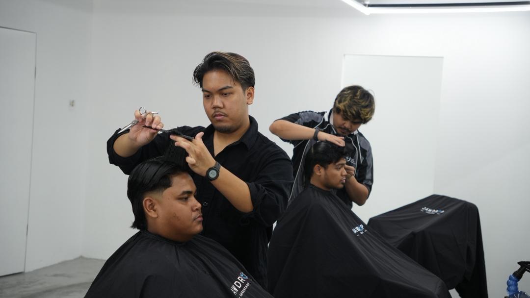 Two Jawdrop barbers shaping fresh cuts in the chair