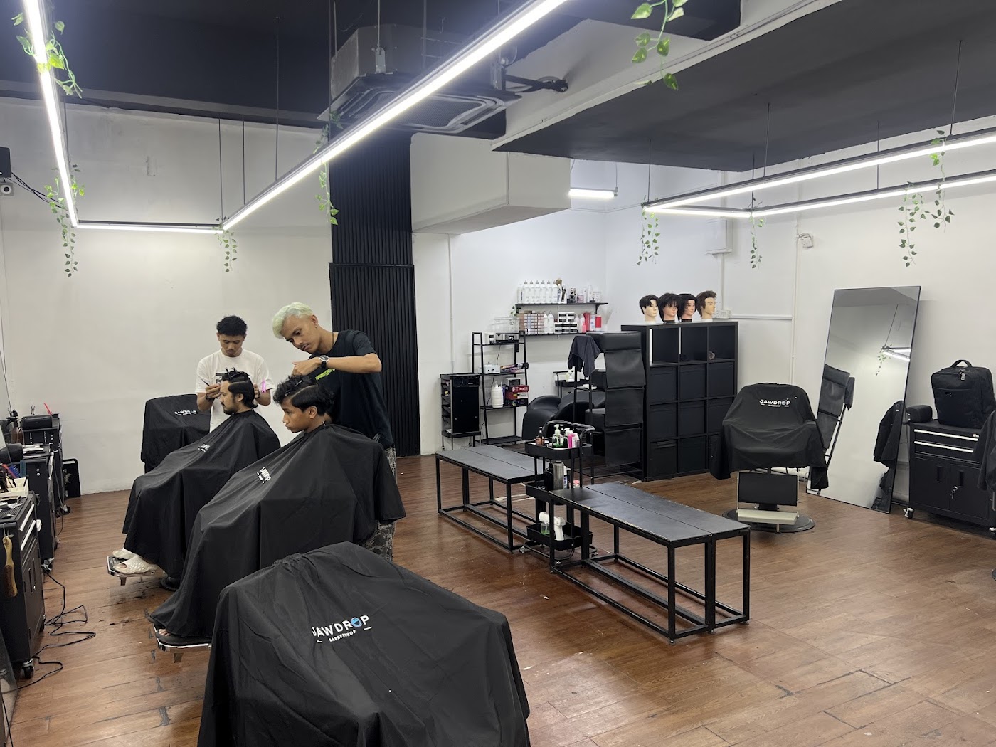 Barbers cutting hair across a row of Jawdrop styling chairs